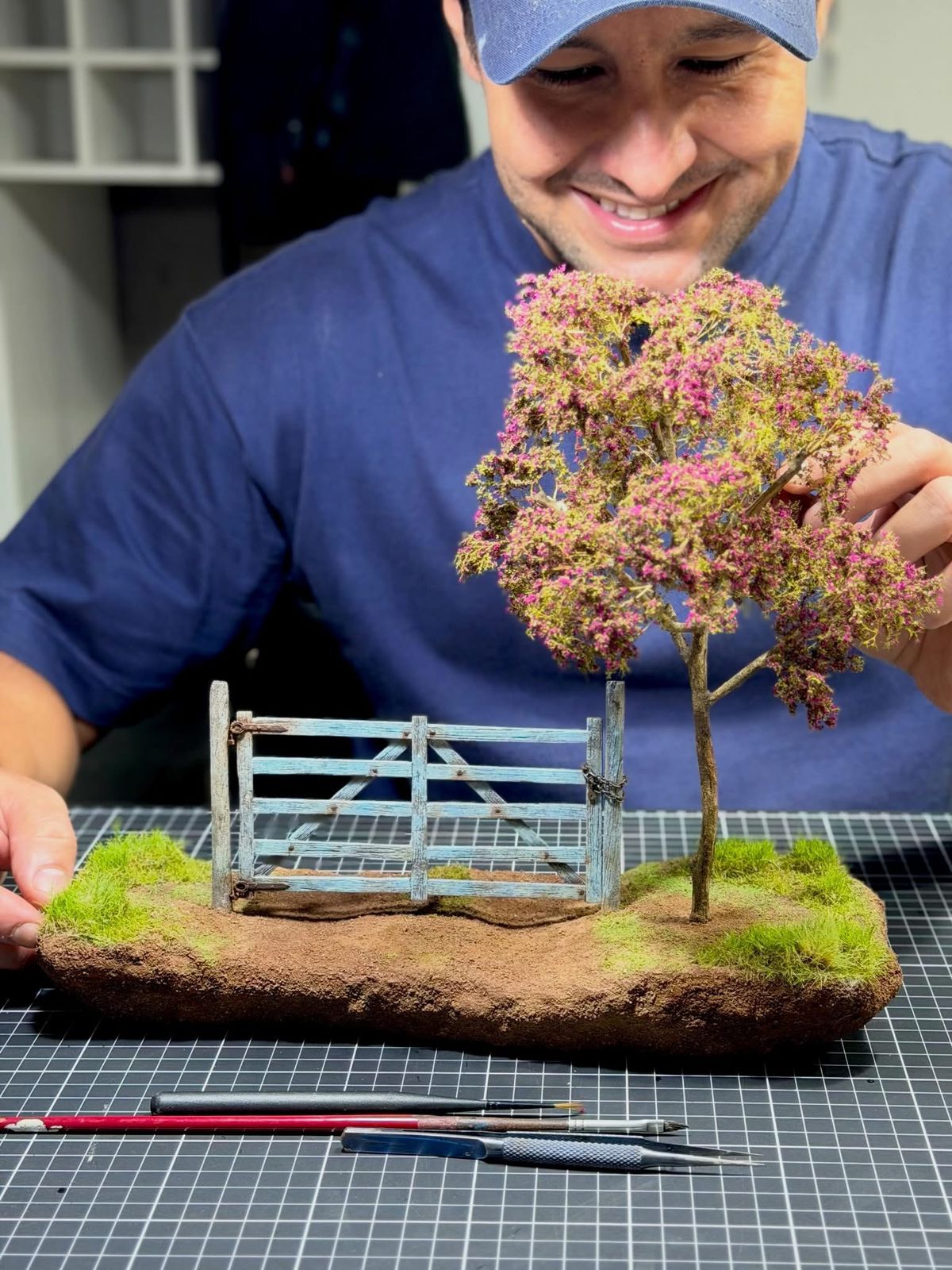 Gustavo Ambrósio sorrindo com miniatura